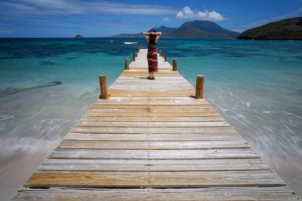 A woman standing on a pier at Turtle Beach in St. Kitts.
